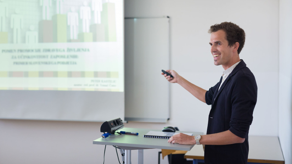 Man pointing at a screen in a classroom