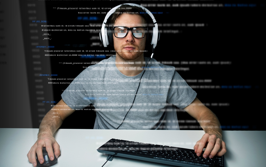 Man with headset using a keyboard and mouse. Photo.