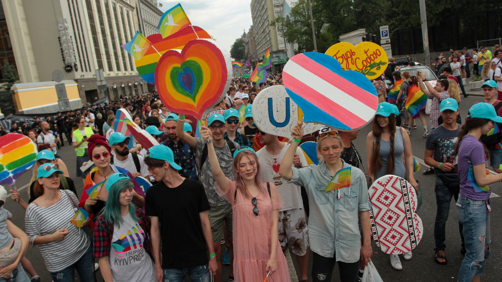unge mennesker i prideparade som holder plakater 