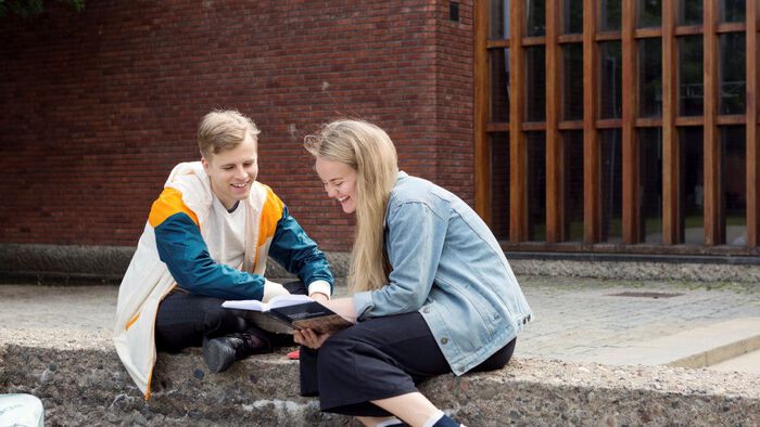 To studenter leser i en bok.