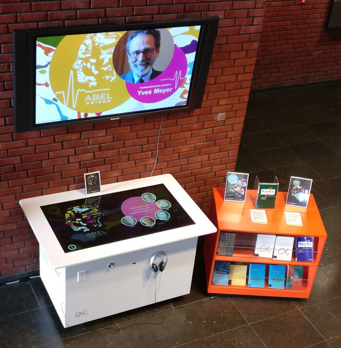 Bildet kan inneholde: tv-apparat, reoler, flatskjerm, dress, elektronisk apparat.